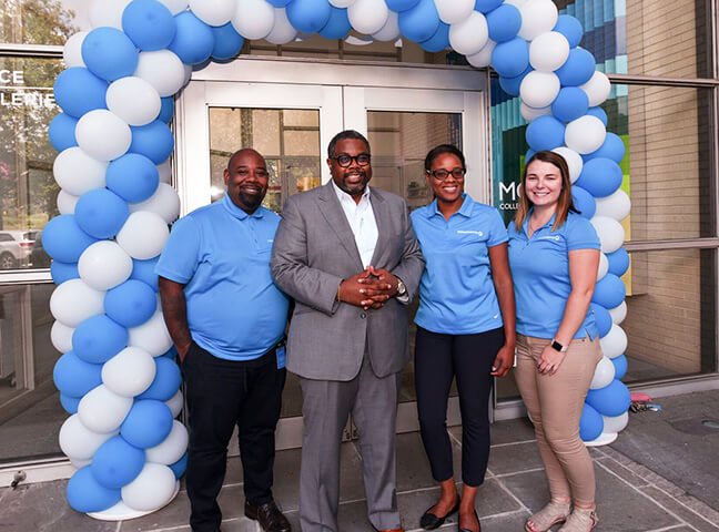 IBX Employees Smiling Under A Balloon Arch