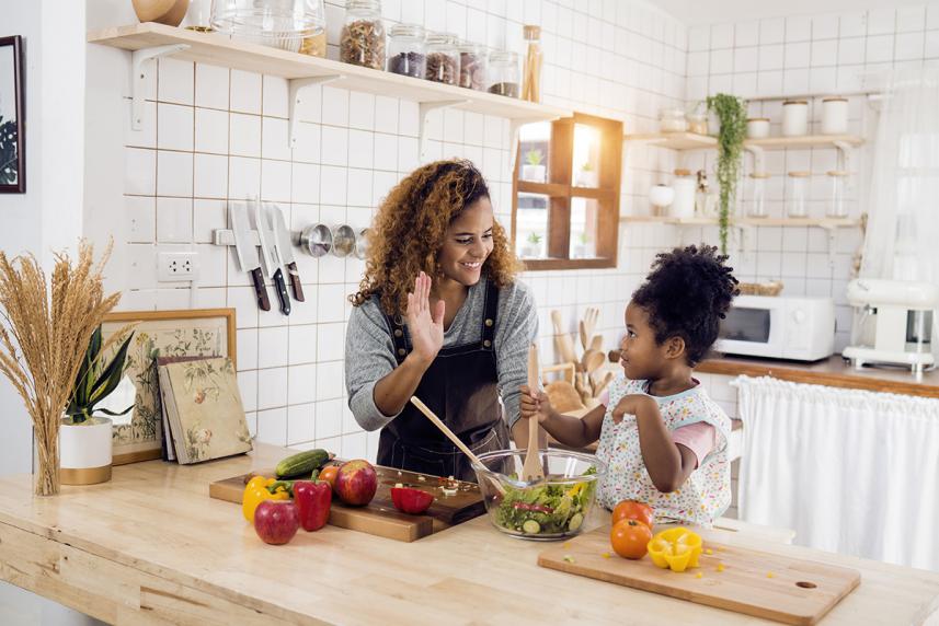 Couple cooking and chopping vegetables together in their kitchen