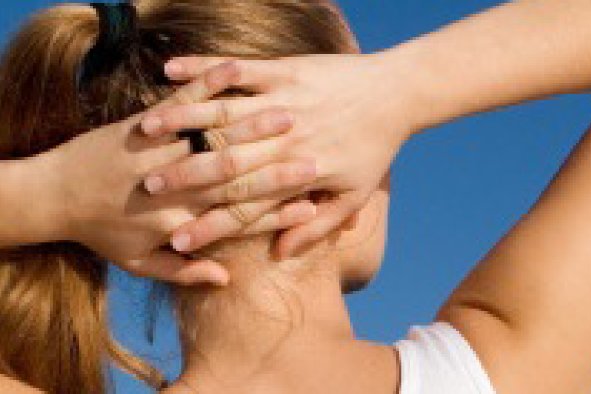 Photo: Rear view of woman stretching with hands clasped behind her head