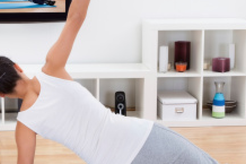 Photo: Woman doing an at-home workout in front of television