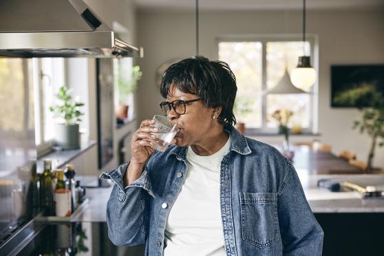 Person drinking water in the kitchen