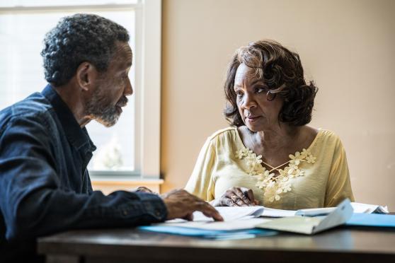 Husband and wife paying bills at table