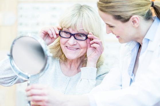 Photo: Older woman trying on glasses