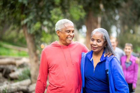 A couple on a walk in a park, holding each other