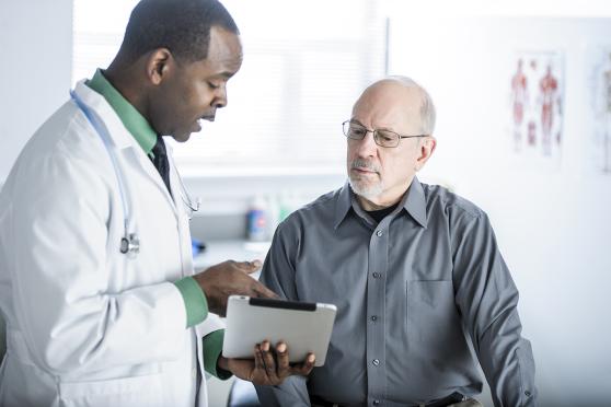 A man and his doctor talk during his annual wellness visit.